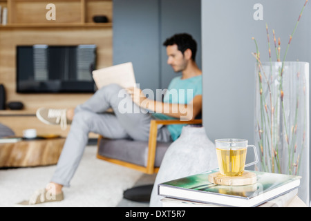 Man reading newspaper in living room Banque D'Images