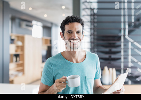 Portrait of smiling man drinking coffee at home Banque D'Images