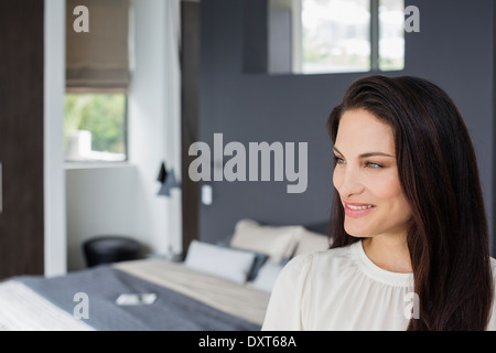 Smiling woman in bedroom Banque D'Images