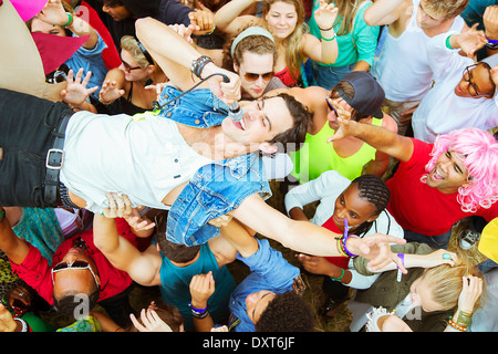 Interprète avec microphone crowd surfing at music festival Banque D'Images