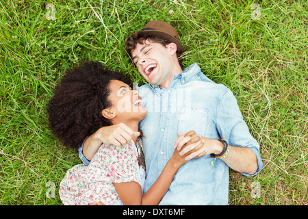 Laughing couple laying in grass Banque D'Images