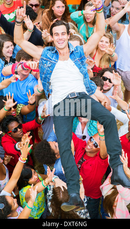 Portrait of man crowd surfing at music festival
