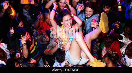 Femme enthousiaste crowd surfing at music festival Banque D'Images
