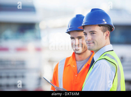 Businessman et worker using digital tablet près de camions Banque D'Images