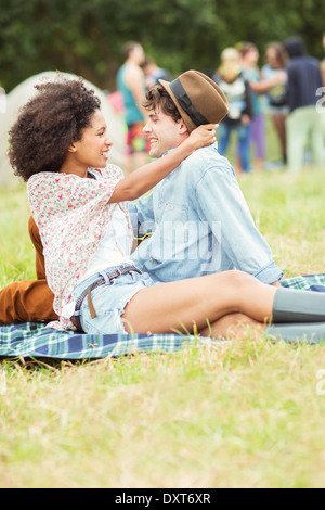 Couple hugging on blanket en herbe à music festival Banque D'Images