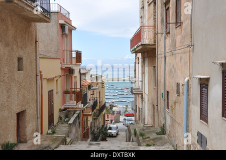 Rue étroite à Castellamare del Golfo, en Sicile, sur la mer Méditerranée en arrière-plan. Banque D'Images