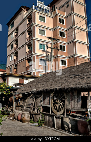 Ancienne chaumière shack accueil éclipsé par des tours d'nouvellement construit appartement. S. E. Asie Thaïlande Banque D'Images