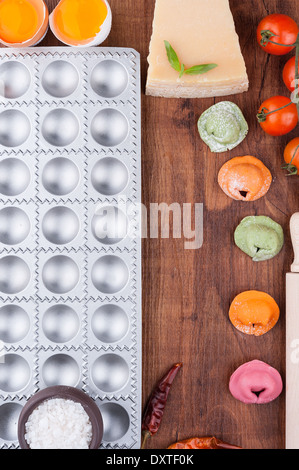 Formulaire pour la cuisson et raviolis multicolores sur une planche en bois Banque D'Images