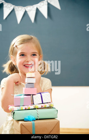 Anniversaire fille assise à pile de boîtes-cadeaux, Munich, Bavière, Allemagne Banque D'Images