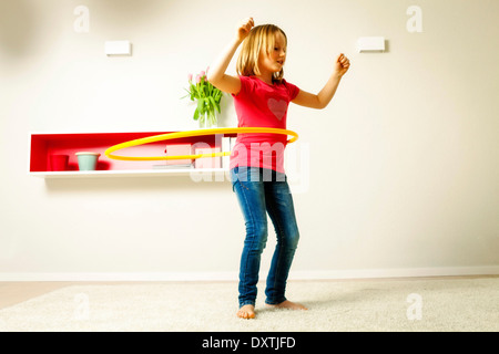 Girl hula hoop dans salon, Munich, Bavière, Allemagne Banque D'Images