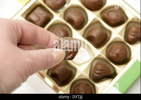 Aider la femme elle-même à un chocolat d'une boîte de chocolats Banque D'Images