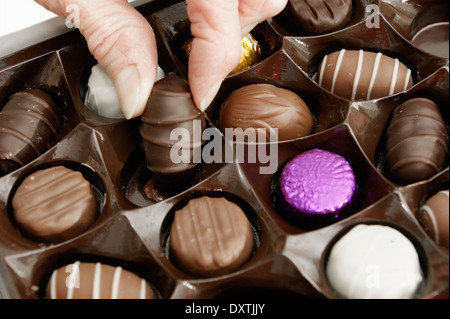 Aider la femme elle-même à un chocolat d'une boîte de chocolats Banque D'Images