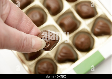 Aider la femme elle-même à un chocolat d'une boîte de chocolats Banque D'Images