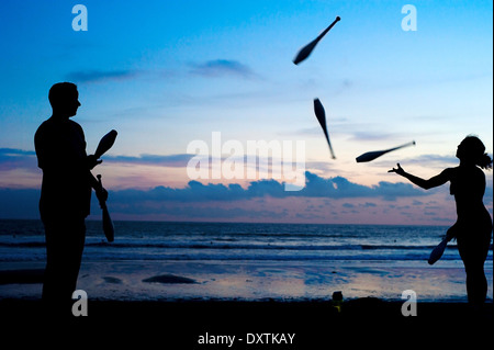 Des personnes non identifiées, jonglant sur la plage au coucher du soleil. Bali, Indonesi Banque D'Images