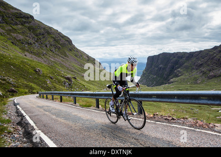 Un cycliste prend la plus longue route en montée Lochcarron, Ecosse Banque D'Images