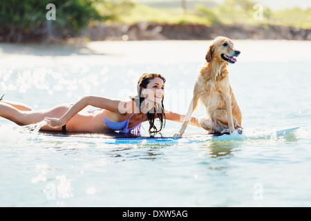 Jolie Jeune femme Surf avec son chien. Surf partage avec Golden Retriever. Banque D'Images