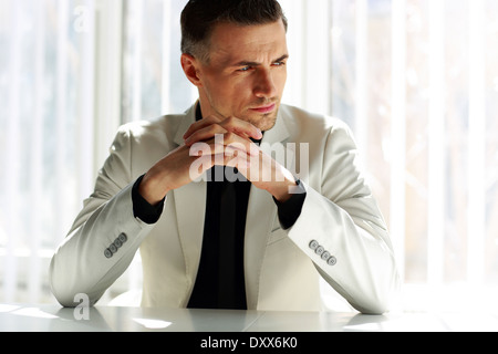Pensive businessman assis à la table et à l'écart Banque D'Images