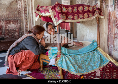 L'Inde, Dehradun. Femme lisant à partir de la Sainte Écriture pour les fidèles à un Sikh Temple construit en 1707. Banque D'Images