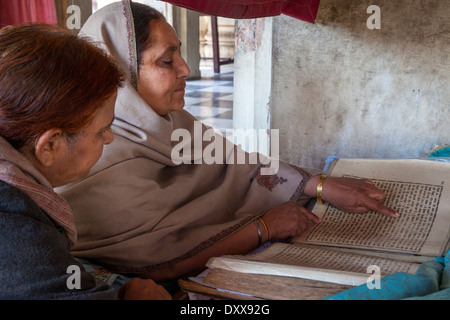 L'Inde, Dehradun. Femme lisant à partir de la Sainte Écriture pour les fidèles au temple sikh construit en 1707. Banque D'Images