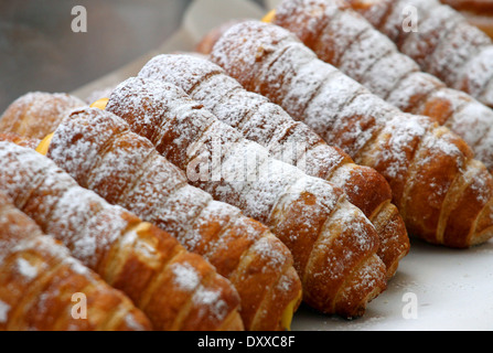 Cannoli énorme farci de jaune crème en vente par confiseur en confiserie Banque D'Images