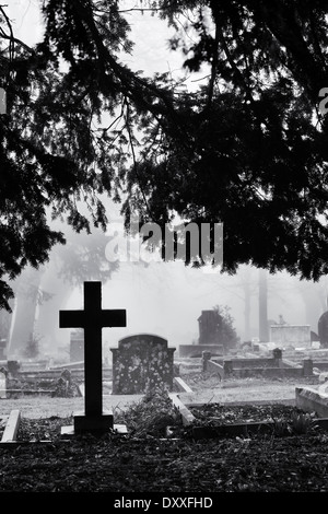 La pierre tombale dans le cimetière de brouillard à Banbury. L'Oxfordshire, Angleterre. Monochrome Banque D'Images