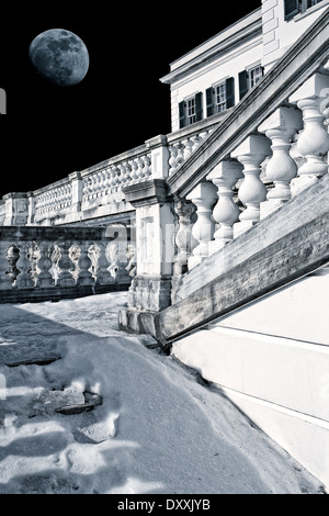 Escalier couvert de neige jusqu'à un âge d'or de l'hôtel particulier sous la pleine lune. Banque D'Images