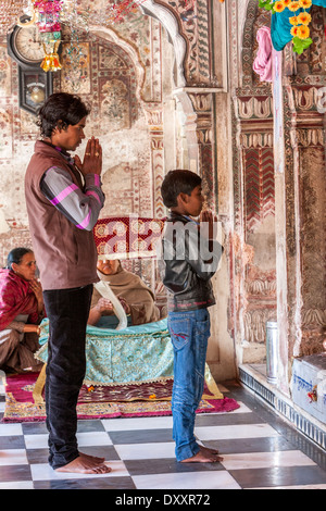 L'Inde, Dehradun. Jeune homme et garçon priant à l'entrée du sanctuaire intérieur du temple sikh. Banque D'Images