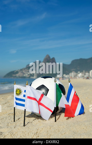 Le football international d'un groupe de pays drapeaux d'équipe avec ballon de soccer sur la plage d'Ipanema à Rio de Janeiro Brésil Banque D'Images