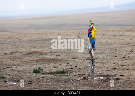 Poteau en bois avec des rubans colorés (jouer rôle important dans le chamanisme) dans le paysage de steppes sur l'île d'Olkhon, le lac Baïkal, Sibérie, Russie Banque D'Images
