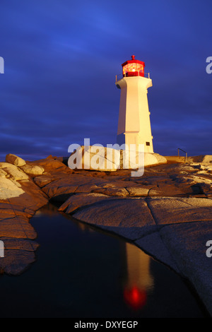 Une peinture de lumière et de réflexion de phare de Peggy's Cove sur une nuit d'hiver orageux, en Nouvelle-Écosse, Canada. Banque D'Images