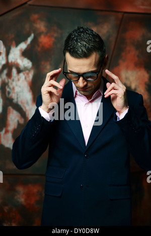 Mode homme cool dans les verres au-dessus de l'arrière-plan industriel Banque D'Images