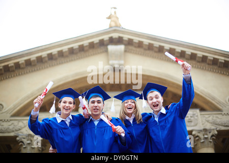 Groupe d'étudiants de toges en extase holding diplomas Banque D'Images