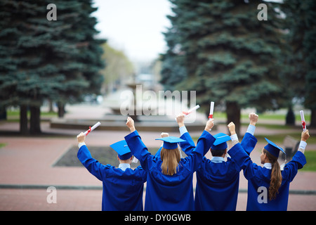 Dos des étudiants de toges en extase holding diplomas Banque D'Images