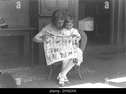 Dans cette image de janvier 1925, la vedette de comédie musicale Dorothy Brunton est vue en train de lire la « Fashion-plate Fanny » de Sid Nicholl dans le journal The Sun, accompagnée d'un petit garçon à l'hôpital Margaret's de Sydney. La photo offre un aperçu de la culture populaire et des médias de l'époque. Banque D'Images