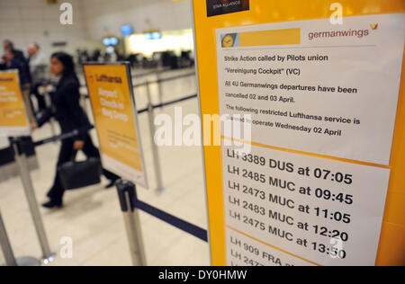 Londres, Royaume-Uni. Apr 02, 2014. Une femme passe par un signe de Lufthansa avec une liste des vols réalisés à l'aéroport Heathrow de Londres, Royaume-Uni, 02 avril 2014. Vols Lufthansa cancelles autour de 3800 en raison de la grève des pilotes. Photo : Andreas Gebert/dpa/Alamy Live News Banque D'Images