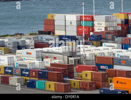 Des piles de conteneurs industriels par un quai dans un port Banque D'Images