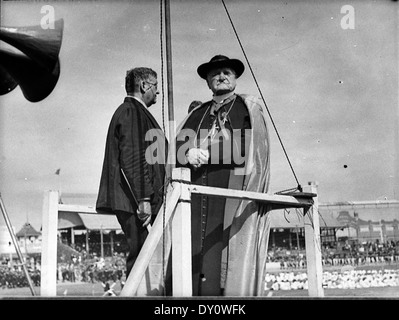 Cette photographie des années 1930 de Sam Hood montre le défilé de la Saint Patrick, capturant les festivités et la participation du cardinal Michael Kelly. L'image souligne l'importance culturelle de l'événement et la célébration publique du patrimoine irlandais en Australie. Banque D'Images