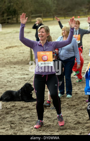 Coureurs bénévoles pour Sport Relief 2014 l'échauffement avant la course, Frensham, UK. Banque D'Images