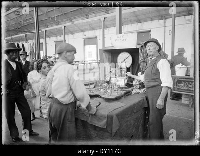 Cette photographie de Rex Hazlewood capture une scène animée du marché de Sydney entre 1911 et 1916. L'image met en valeur l'atmosphère commerciale dynamique de Sydney au début du XXe siècle. Banque D'Images