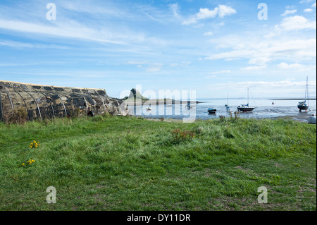 Château de Lindisfarne [Saints] de l'île et le quartier du port avec bateaux amarrés et réflexions dans Northumberland England UK Mer Banque D'Images