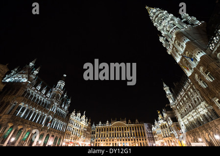 Grand Place illuminée la nuit Bruxelles Belgique | BRUXELLES — Les projecteurs sculptent le tracé gothique de la tour de l’Hôtel de Ville qui s’élève au-dessus de la Grand-Place la nuit, la place du marché qui ancrait la vie civique dans la capitale belge depuis le douzième siècle. Le flèche ajourée de la tour, achevée sous l’architecte Jan van Ruysbroeck à partir de 1449, illustre le style gothique brabançon au sommet du pouvoir marchand de la ville. Banque D'Images
