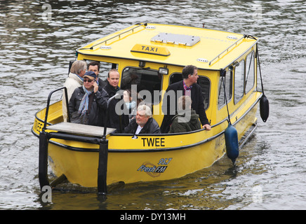 Les personnes à l'eau taxi jaune sur canal à Amsterdam, Pays-Bas Banque D'Images