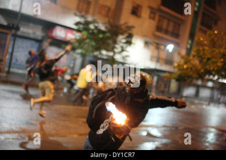 Caracas, Venezuela. 2 avril, 2014. Un manifestant lance une Police nationale une bombe incendiaire à Chacao pour protester contre la violation des droits économiques, l'inflation et la censure de l'information le 2 avril 2014. L'Église catholique romaine au Venezuela a accusé le gouvernement pour imposer un "gouvernement totalitaire'. (Photo de Rafael Hernandez / Pacific Press) Banque D'Images