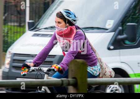 Londres, Royaume-Uni. 06Th avr, 2014. Un cycliste porte un masque improvisé. La pollution de l'air est élevé à Londres en raison d'émissions des véhicules et des industries le mélange avec le sable du désert pour créer un brouillard léger comme le smog. Cela n'empêche pas les cyclistes et les coureurs d'exercer dans ce autour de Clapham Common pendant les heures de pointe. Clapham, Londres, Royaume-Uni, 03 avril 2014. Crédit : Guy Bell/Alamy Live News Banque D'Images