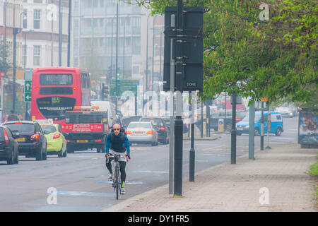 Londres, Royaume-Uni. 06Th avr, 2014. La pollution de l'air est élevé à Londres en raison d'émissions des véhicules et des industries le mélange avec le sable du désert pour créer un brouillard léger comme le smog. Cela n'empêche pas les cyclistes et les coureurs d'exercer dans ce autour de Clapham Common pendant les heures de pointe. Clapham, Londres, Royaume-Uni, 03 avril 2014. Crédit : Guy Bell/Alamy Live News Banque D'Images