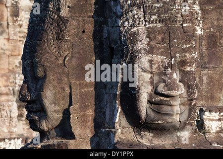 Deux visages de pierre sculptée dans temple Bayon à Angkor près de Siem Reap, Cambodge Banque D'Images