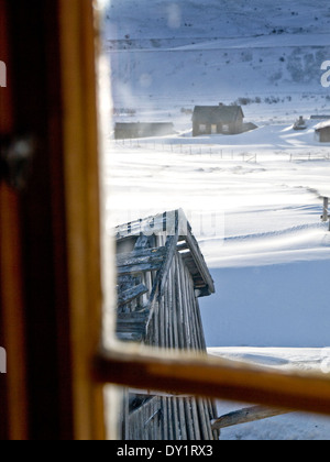 La ferme en montagne en hiver norvégien vu par la fenêtre d'une cabane Banque D'Images