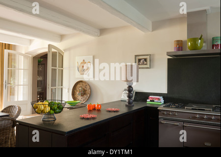 Cuisinière Lacanche en bois sombre et dans des unités au sol en pierre cuisine avec plafond à poutres apparentes traditionnelles Banque D'Images