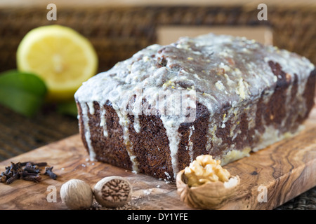Ensemble de maison glacé date et walnut cake sur planche de bois et tissus de bac. Banque D'Images