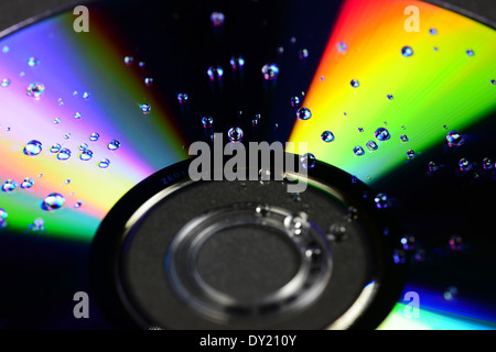 Disque compact avec des gouttes d'eau isolé sur fond noir Banque D'Images